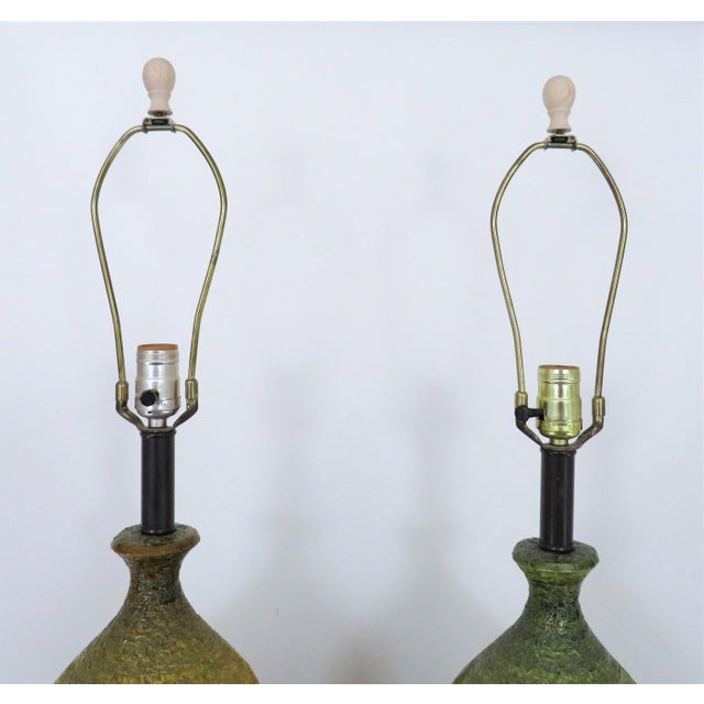 This is a set of LARGE vintage ceramic table lamps. Mid century modern. One is more green with yellow stripes and the...