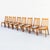 A striking set of Scandinavian mid century modern solid teak dining chairs with warm honey-toned grain, sculptural side...