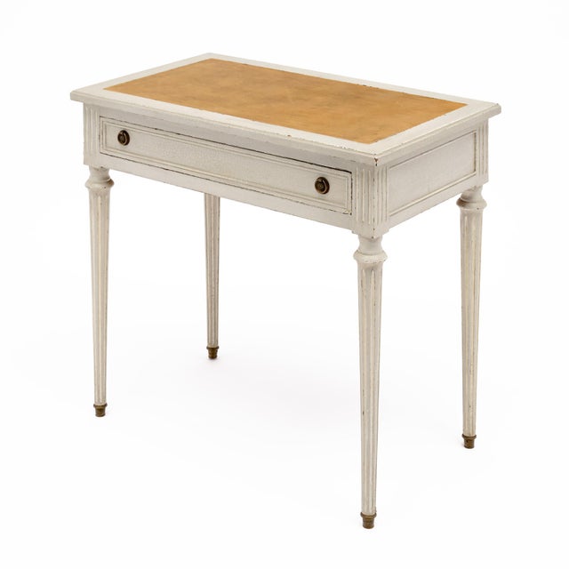 A charming French Louis XVI style writing desk dating to circa 1920, crafted in cherrywood and finished in a softly...