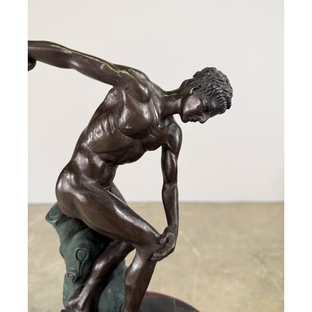 Finely cast bronze sculpture inspired by the classical athletic form of ancient Greece, depicting a male figure in a...
