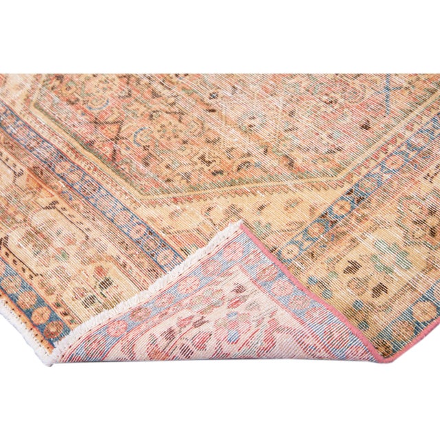 Beautiful vintage Malayer hand-knotted wool rug with a pink field. This Persian rug has blue, green, and brown accents in...