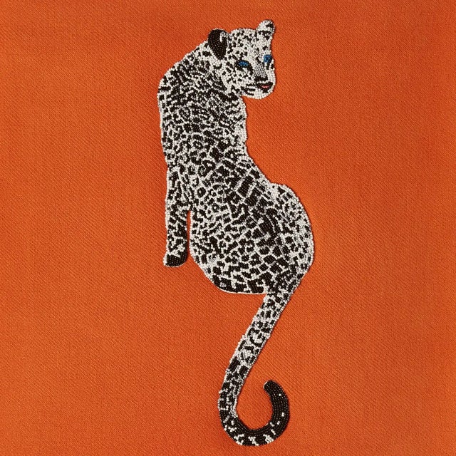 Fabulous Feline. Hand-embroidered by artisans, our bold orange embellished throw features our favorite symbol of timeless...