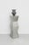 Vintage illuminated pedestal featuring a sculptural faceted silhouette in a brushed metal finish with a recessed glass...