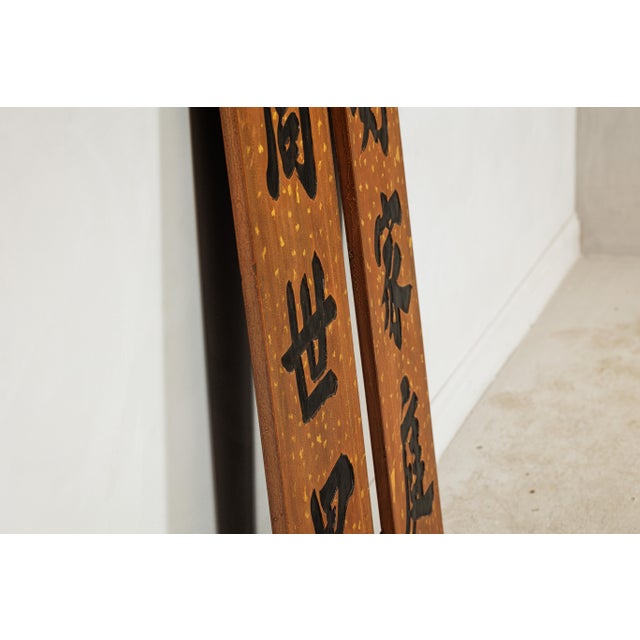 This pair of vertical Chinese signs, dating to the early 20th century, is richly decorated with bold hand-carved...