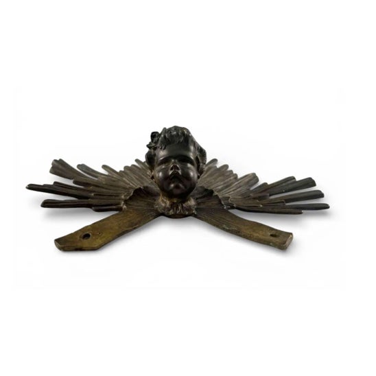 A striking 19th century cast bronze cherub head set within a radiating sunburst halo, originally part of a larger...