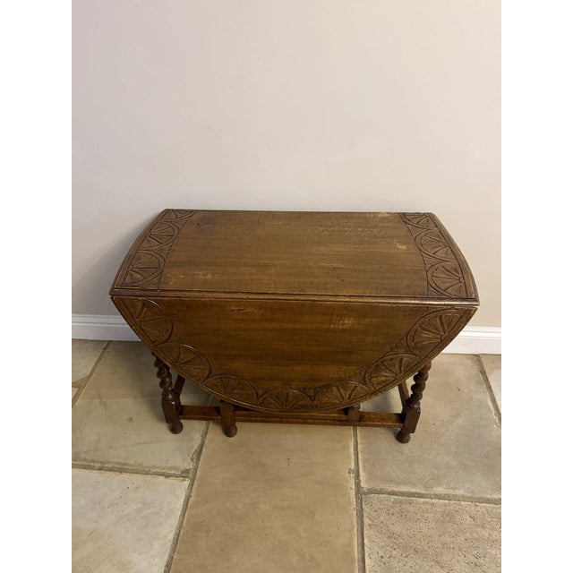 Fine quality antique oak drop leaf dining table, having a quality antique oak top with two drop leaves with carved detail...