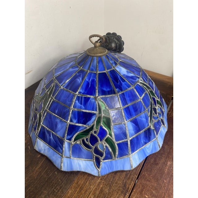 Magnificent stained-glass style pendant light. Circular lampshade, tinted glass in shades of light and dark blue, upon...