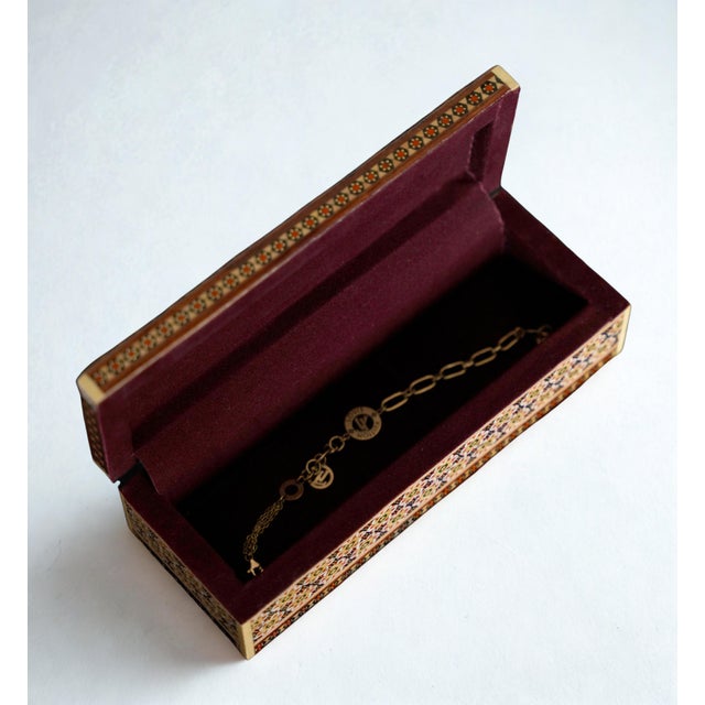 This hand-painted jewelry box features a miniature-style Leili o Majnoun scene, framed with intricate Khatam-style...