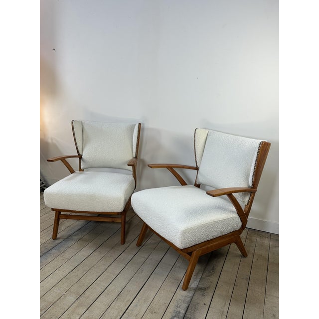 Pair of vintage 1950s wood and fabric armchairs. with their organic lines typical of mid-20th-century design, these...