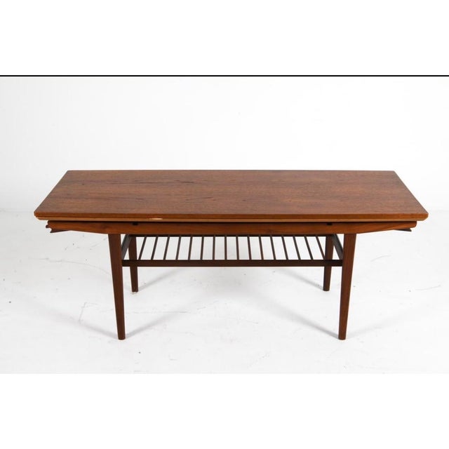 Teak coffee table with (2) leaves stored within table. Top elevates. Unmarked, attributed to Kai Kristiansen. Denmark,...