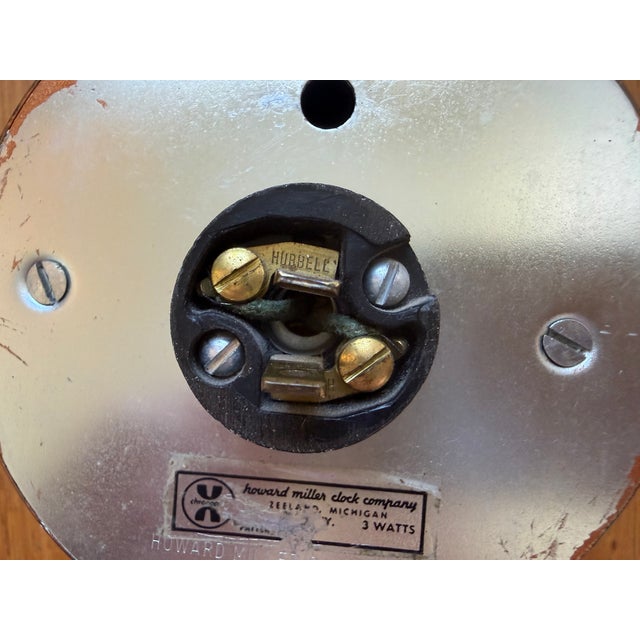 Original condition George Nelson "Steering Wheel" clock manufactured by Howard Miller, USA. Painted wood, brass, painted...