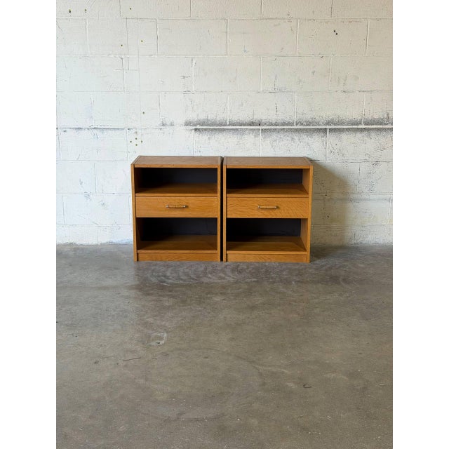 This matching set of nightstands features clean architectural lines, open display cubbies, and smooth pull-out drawers....