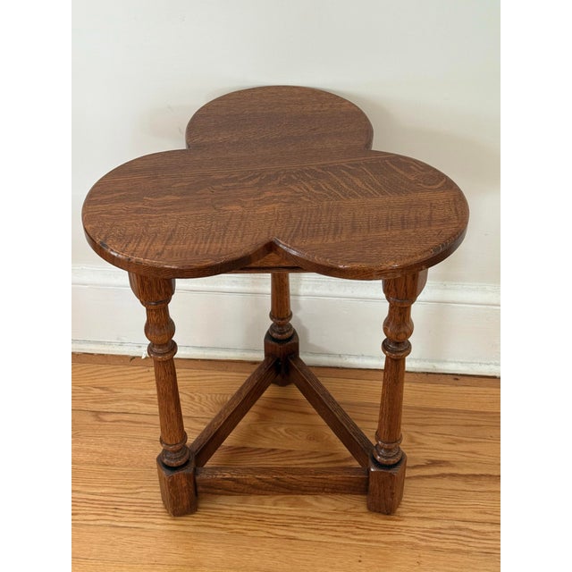 A fine English cricket table of oak featuring a clover top over a tripod base with triangular brace. A charming occasional...
