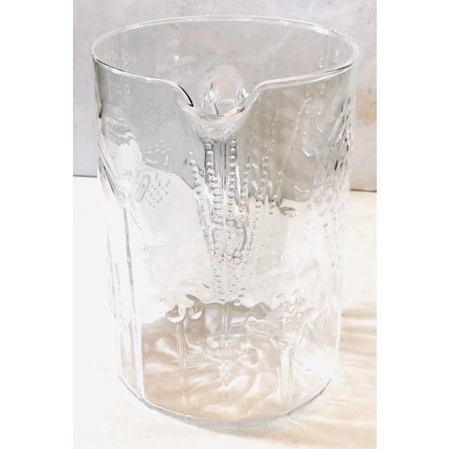 Charming Finnish glass pitcher hand pressed with whimsical trees surrounding it and the traditional swirled bottom by...