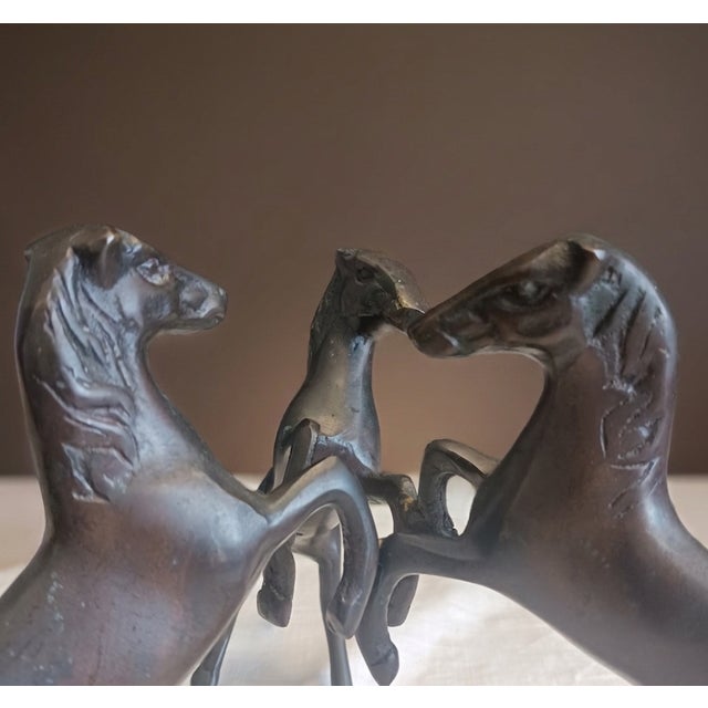 This heavy, solid bronze figurine features three spirited stallions expertly joined to form a single integrated tripod...