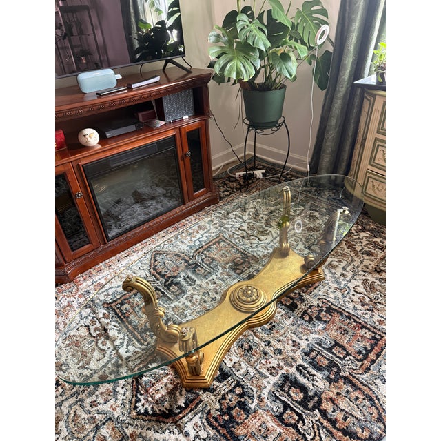 Beautiful vintage Weiman Heritage oval coffee table featuring a carved wood base with an antique gold leaf finish and a...