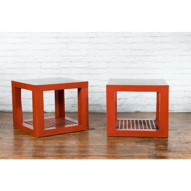 A pair of Chinese elmwood cube shaped side tables from the late 20th century made with antique red lacquered elmwood and...