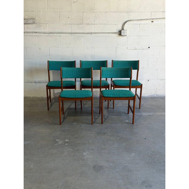 This vintage set of 5 dining chairs exhibits a classic Scandinavian silhouette featuring contoured backrests and iconic...