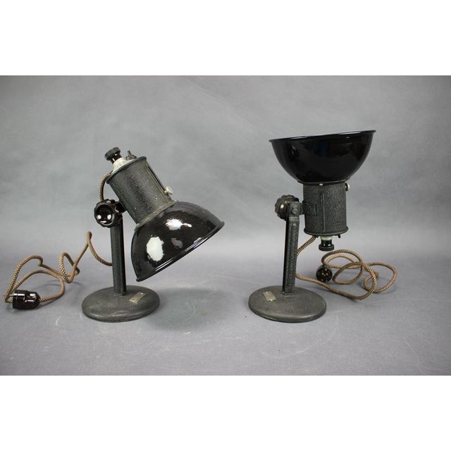 An impressive pair of original industrial desk lamps dating from 1955, featuring black-painted metal construction, glossy...