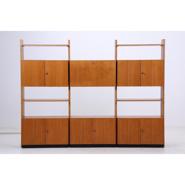 A beautiful Musterring wall unit from the 1960s with a clear, modular structure and a calm wood finish. Open compartments,...