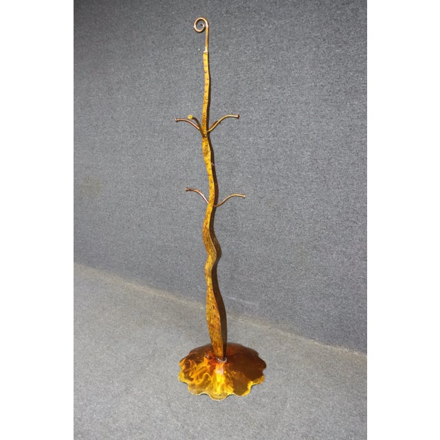 A striking mid-century sculptural coat rack featuring a sinuous, hand-forged metal form with an organic flow reminiscent...