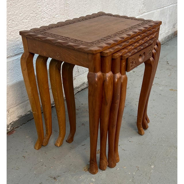 Add elegance and versatility to your space with this Set of Four Carved Antique Nesting Tables, a stunning blend of...