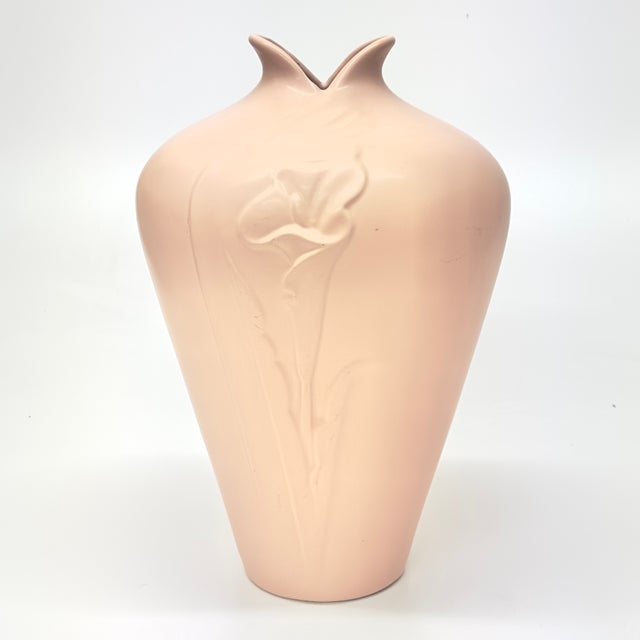 This is a rare 1980s matte blush-pink ceramic vase by Haeger featuring a raised relief lily motif. Approx. Measurements :...