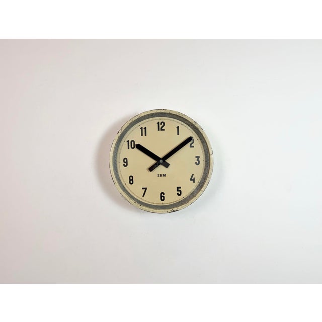 This wall clock was produced by IBM in USA during the 1950s. It features a beige metal frame, iron dial, aluminium hands...