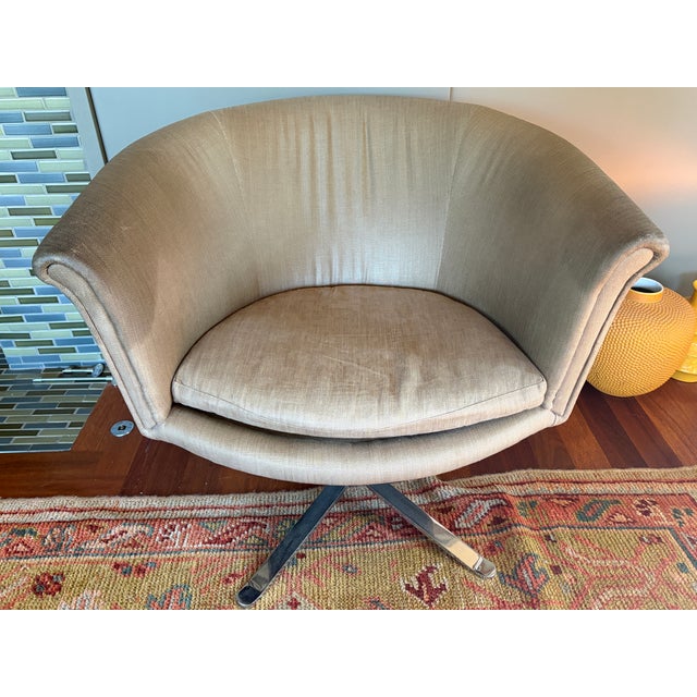 A striking and incredibly comfortable pair of mid-century modern swivel barrel-back lounge chairs, circa 1970s. These...