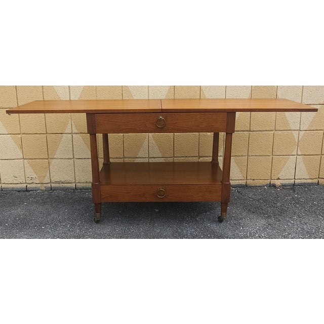 A Mid-Century Heritage-Henredon Walnut Expendable Rolling Buffet Server with two drawers. Measures 34" in width, 68" in...