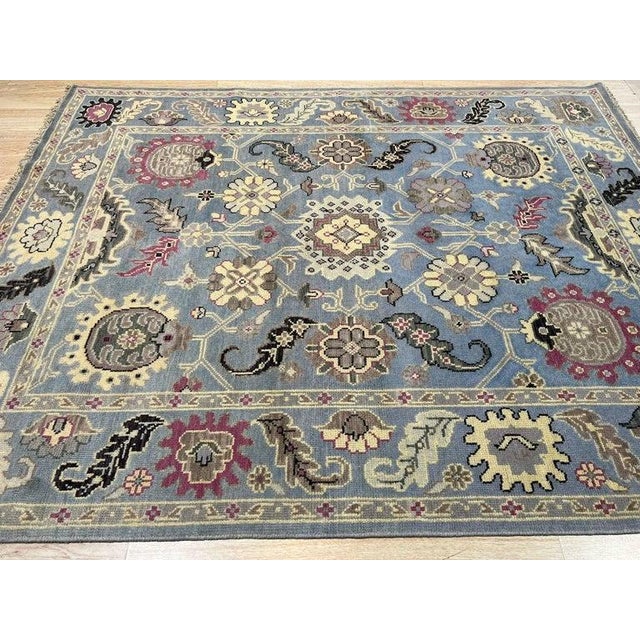 This blue wool rug features a durable hand knotted pile weave. Crafted in India, it showcases the distinct Nain style...