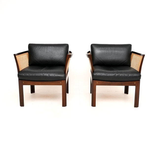 A stylish and very rare pair of vintage Danish cane and leather armchairs by Illum Wikkelso. This model is called the...