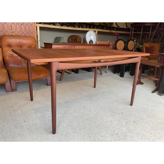 A teak extending dining table designed by ib kofod-larsen for g plan for their danish range. The rectangular top...