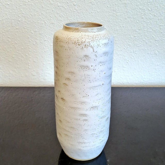 A beautiful, snow-white, cylindrical vase from the East German studio of master potter Albert Kießling. The texture left...