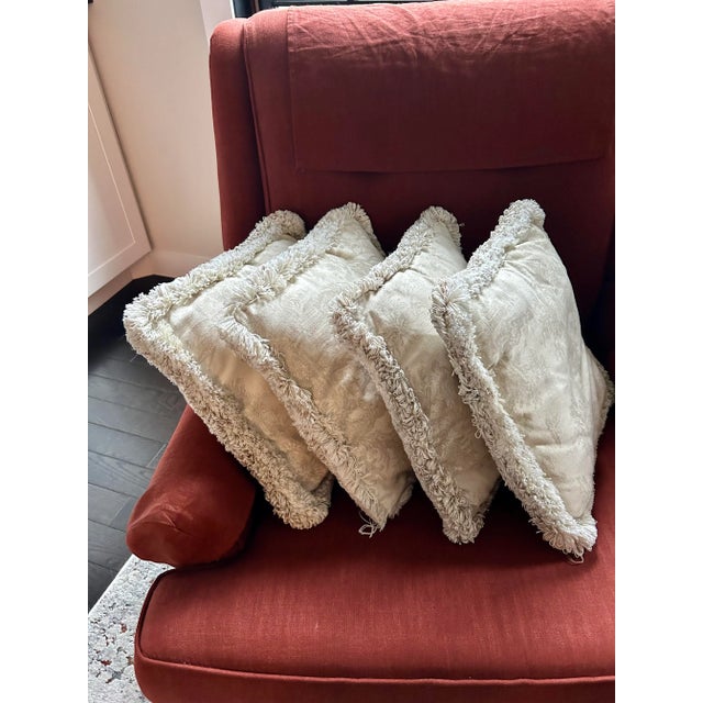 Here's a set of four ecru and taupe colored linen toile throw pillows with thick fringed edges. They are in nearly...
