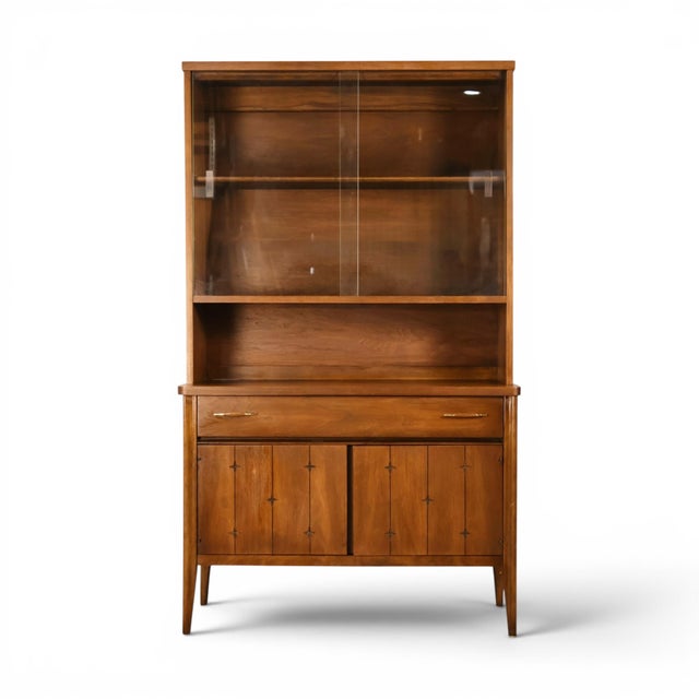 This 1960s Broyhill Saga petite china cabinet brings the collection's signature incised star motif to a china cabinet...