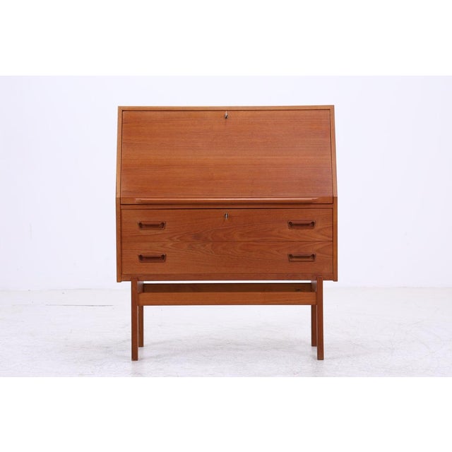 Vintage teak secretary desk by Arne Wahl Iversen with clean lines and a functional interior layout. Behind the writing...