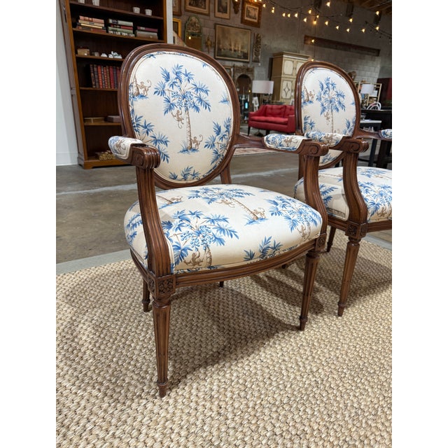 Elegant matched pair of Louis XVI style fauteuils — the classic French neoclassical open-arm chair, with beautifully...