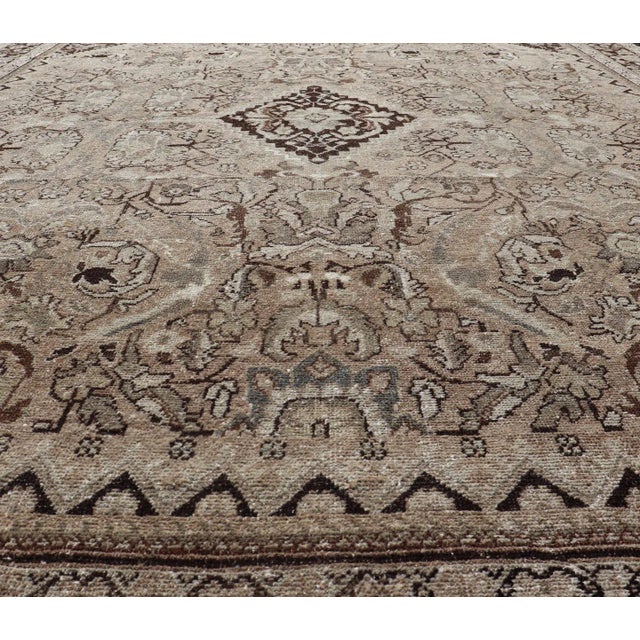 This vintage Sultanabad-Mahal rug features a sub-geometric diamond design with herati motifs. The rug is set upon a taupe...