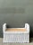 A vintage braided white rattan ottoman with a sturdy woven construction, crisp white finish, and decorative braided edging...
