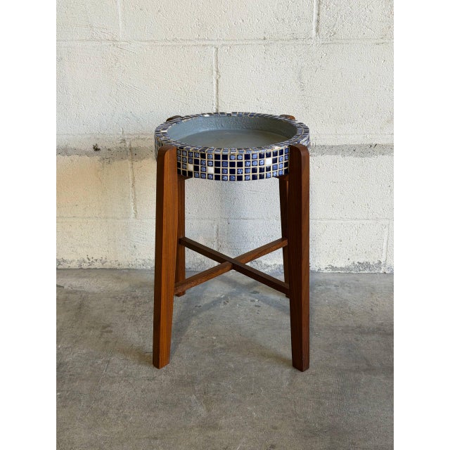 This planter stand features a round mosaic tile basin set atop an architectural teak frame with cross stretchers. Its...