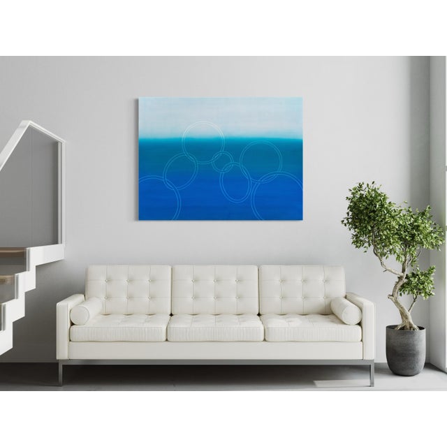 A pale, hazy sky sits over a deepening field of ocean blue that fills the lower two-thirds of the canvas, the transition...
