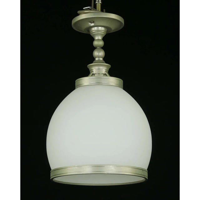 Modern style semi flush mount light with a white glass shade and brushed steel fitter and shade band. This light requires...