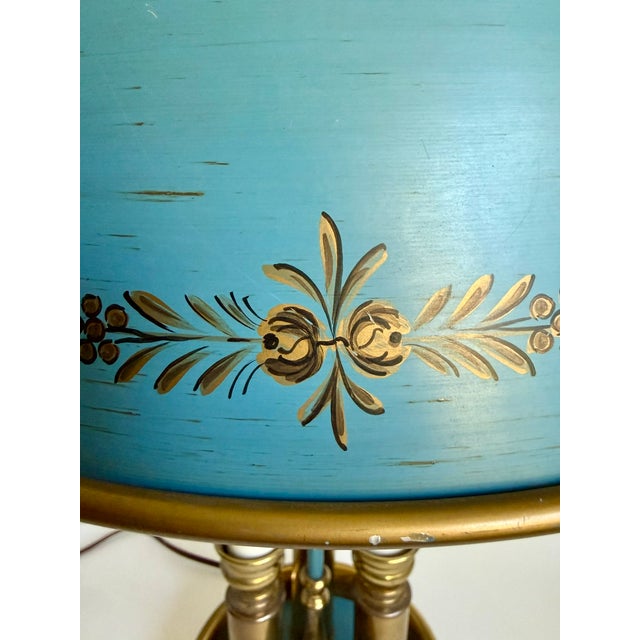This vintage French Empire Revival bouillotte lamp features a beautifully painted blue tole shade, warm brass hardware,...