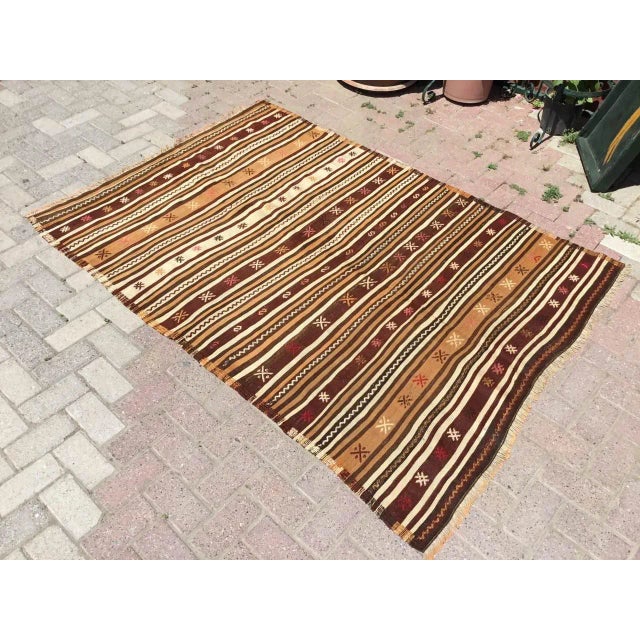 This beautiful, vintage, handwoven kilim rug is approximately 60 years old. It is handmade of hand spun wool in all...
