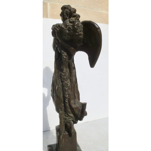 Italian Bronze of an allegorical angel holding long garlands of celebratory flowers. Striking an aloof pose and holding up...