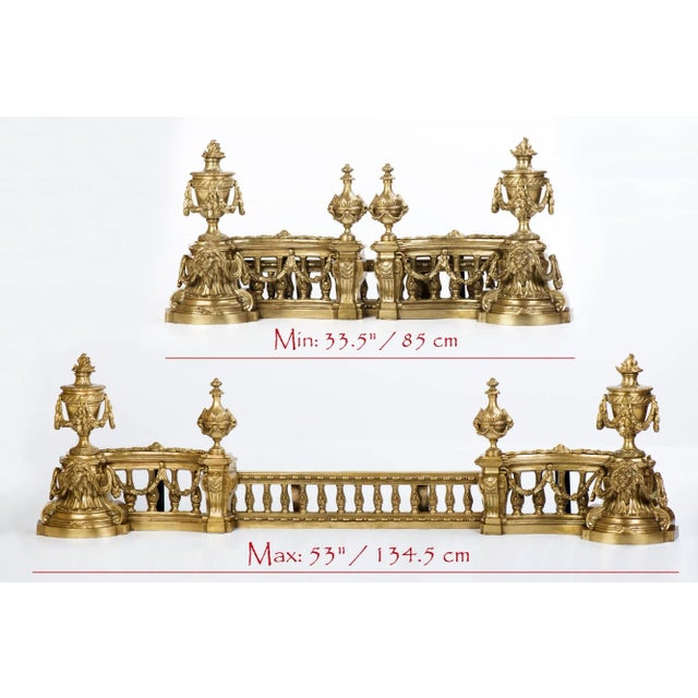 Antique French extending brass fender having classical shaped urns to each side and lion heads supporting an elaborate...