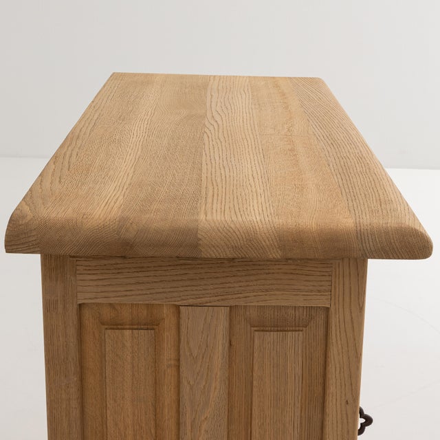A Brutalist oak cabinet featuring thick construction and iron details. The piece is defined by its strong geometric form...