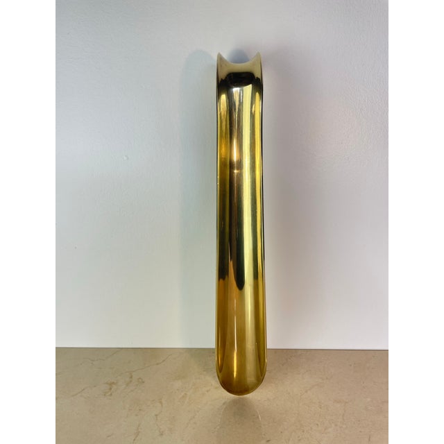 Substantial vintage shoehorn in solid brass with a warm, unlacquered patina and a graceful curled hook at the top for...
