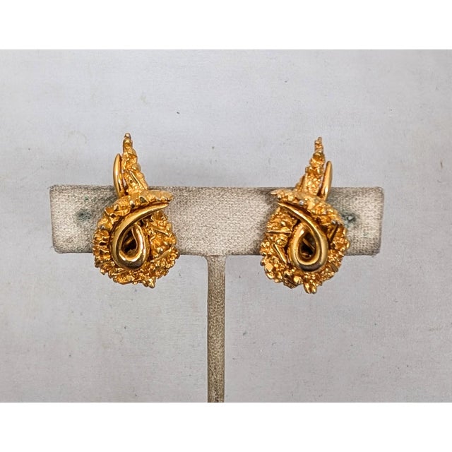 Early 1960s modernist goldtone loop with smooth inside and textured outside clip earrings. Marked "©BOUCHER" with...